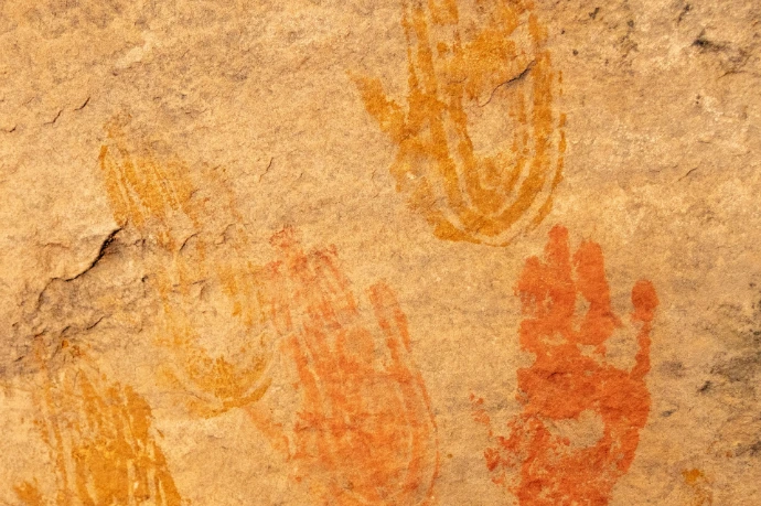 Ancient handprints painted on a rock surface.
